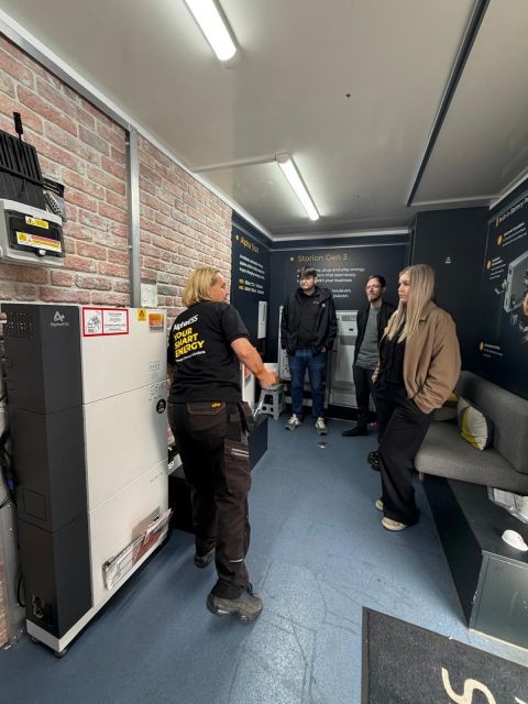 Emma Dutton showing installers AlphaESS battery storage systems inside BESSIE
