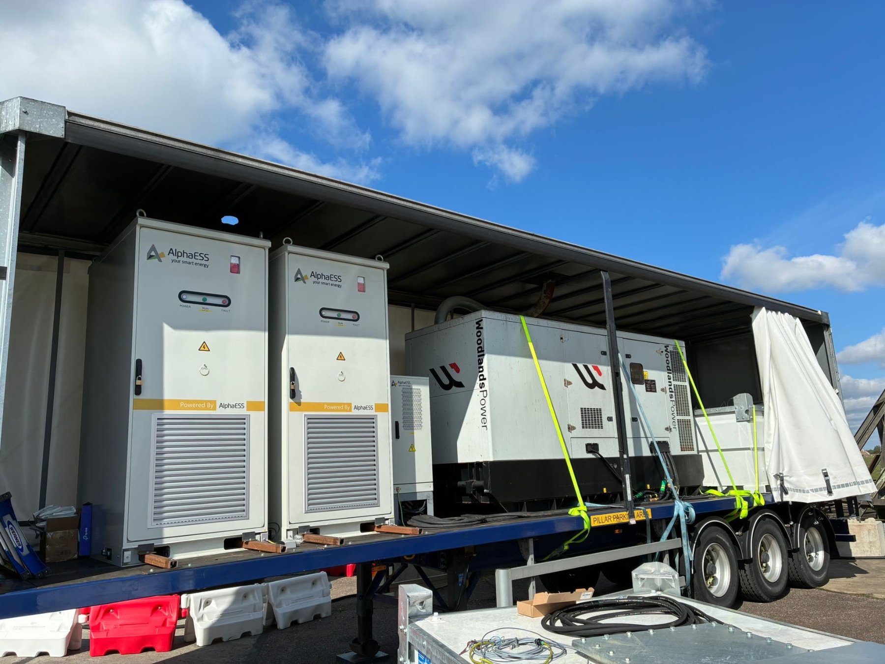 Quest Power mobile power trailer carrying AlphaESS STORION TB125 batteries alongside a backup generator
