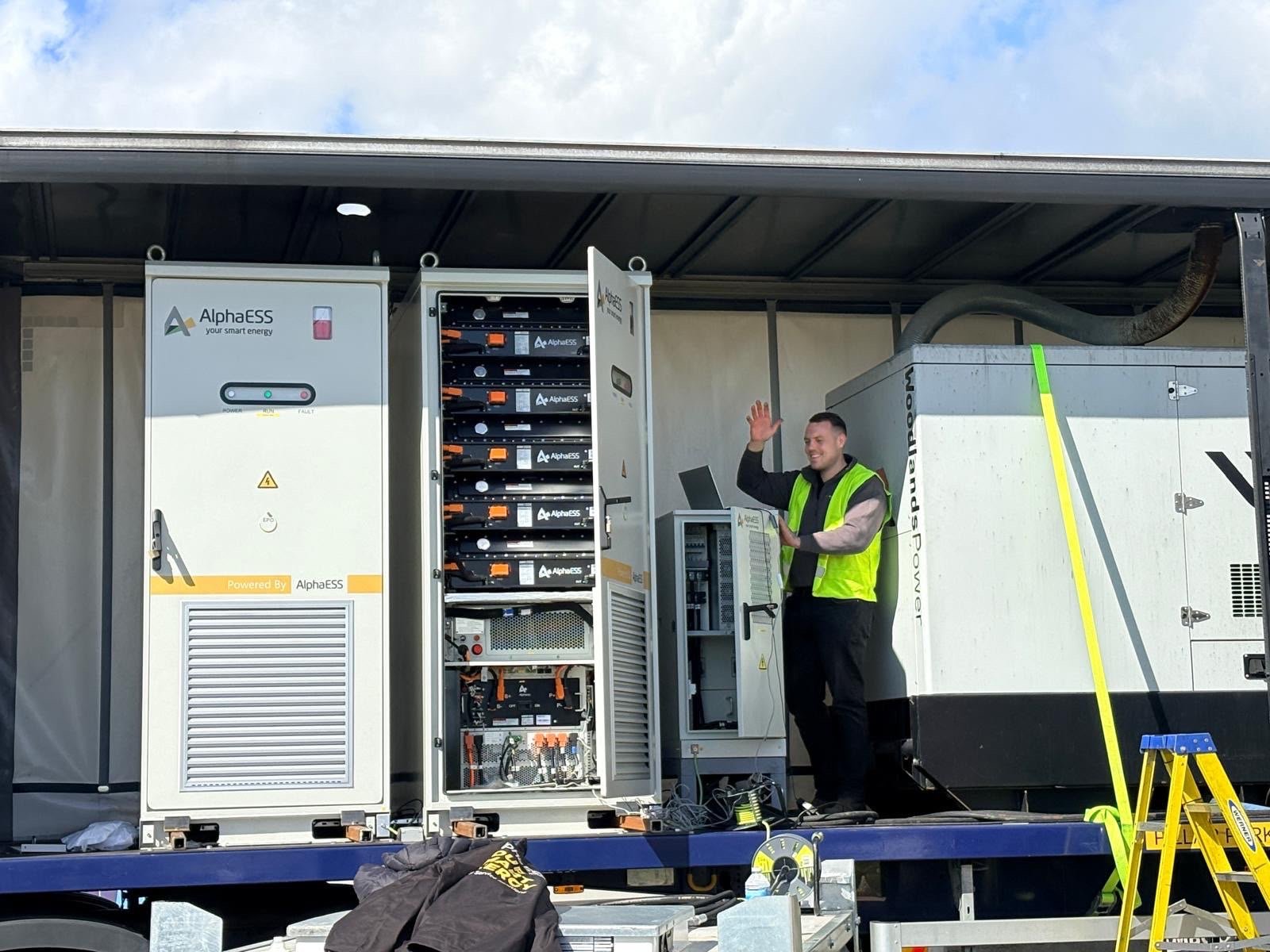 Engineer with two AlphaESS STORION TB125 batteries and a generator on a Quest Power trailer